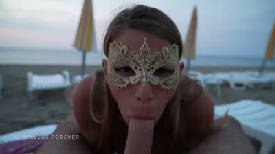 Fellation sur la plage de fille sexy et nue avec un masque